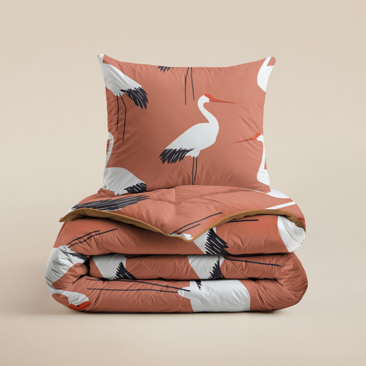 Het Zelesta Kiddybed Katoen - Terra Crane heeft een gevouwen hypoallergeen dekbed en bijpassend kussen met een roestkleurige achtergrond en witte kraanvogelprint, ideaal voor de kinderkamer, afgebeeld op een effen beige achtergrond.