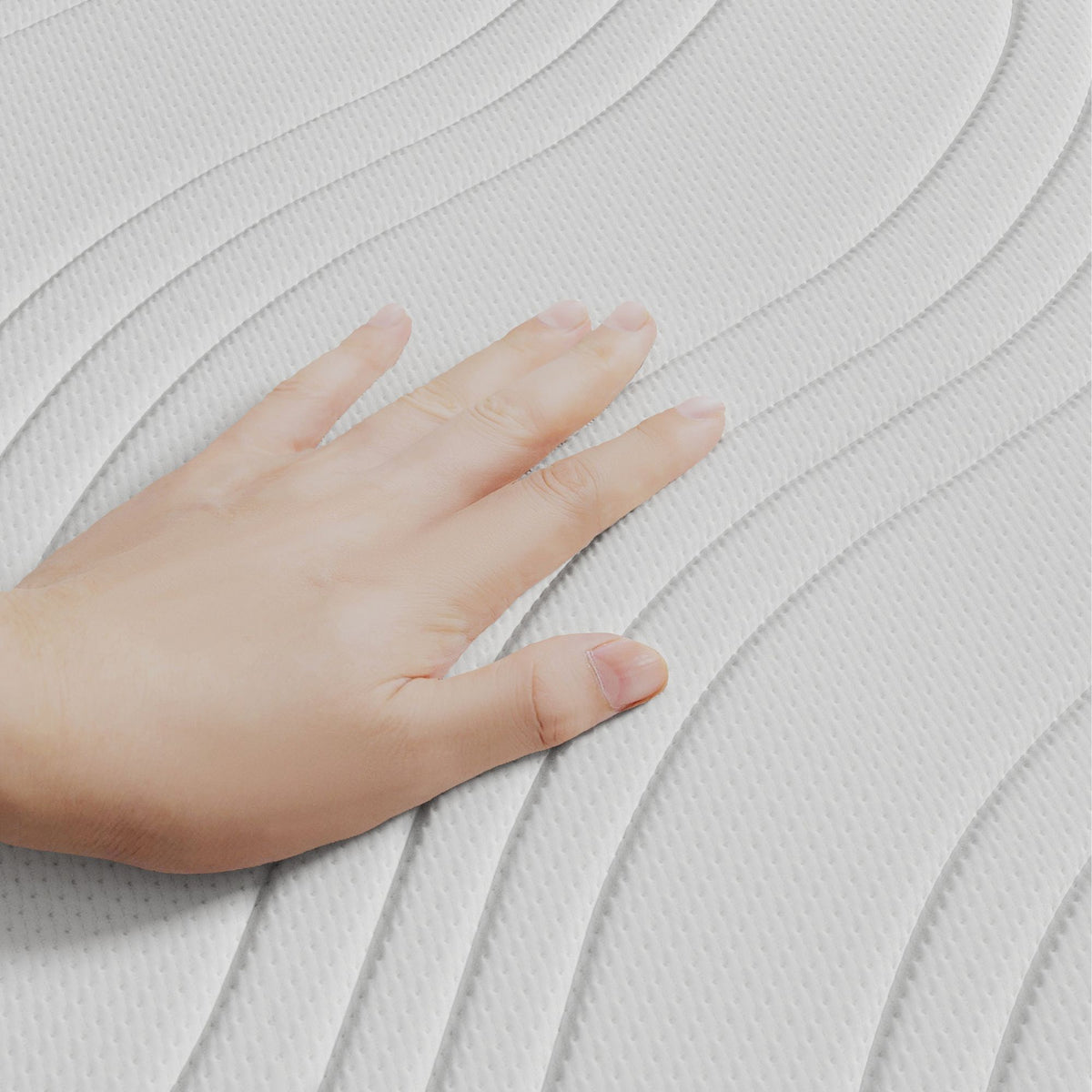 Een hand raakt het witte, golvende oppervlak van de Topdekmatras - NASA Schuim Cool Fresh Tijk aan en benadrukt de drukverlagende ondersteuning.