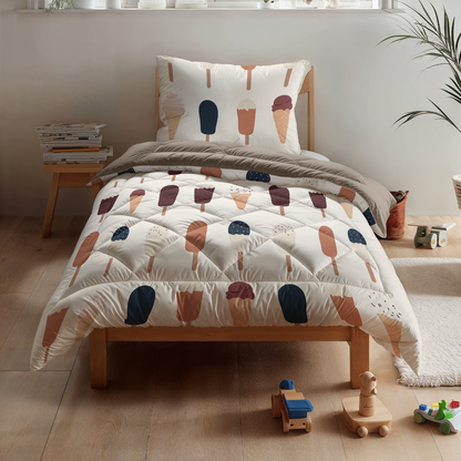 Het Zelesta Kiddybed Katoen - Gelato heeft beddengoed met een ijsco-thema en een anti-allergisch dekbed in een kinderkamer met een houten vloer, overal speelgoed en boeken naast het kleine bed.