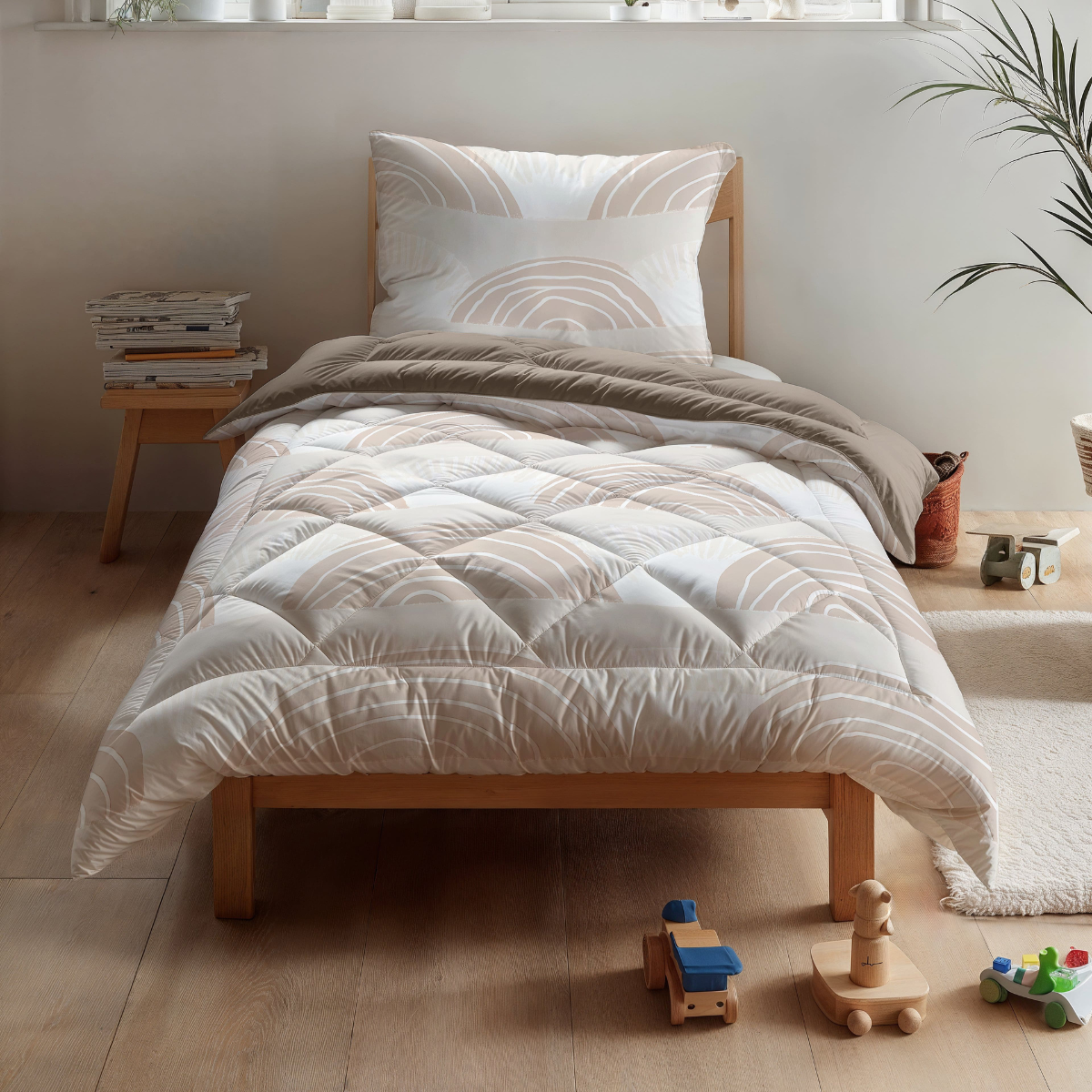 Een keurig opgemaakt eenpersoons wasbaar kinderbed met Zelesta Kiddybed Katoen - Dune Dreams beddengoed in een lichte kamer, met houten speelgoed, boeken, een anti-allergisch dekbed en een potplant op de vensterbank.