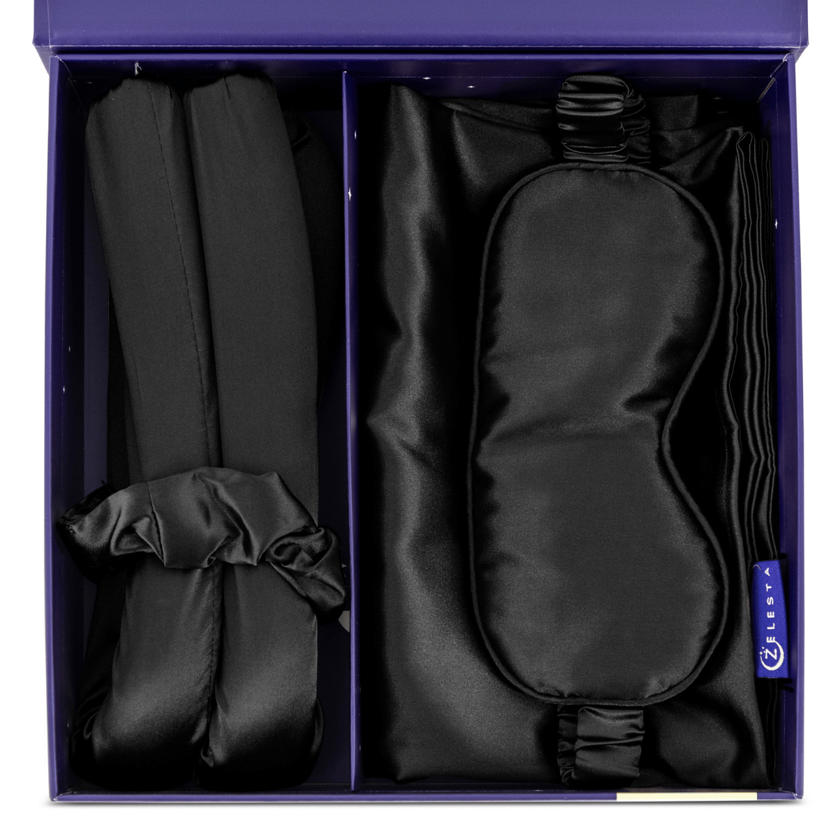 De Zelesta Sleeping Beauty Set - Universal Black bestaat uit een zwart zijden slaapmasker, een Mulberry zijden kussensloop en twee scrunchies, allemaal elegant gerangschikt in een paarse geschenkdoos voor een anti-aging touch.