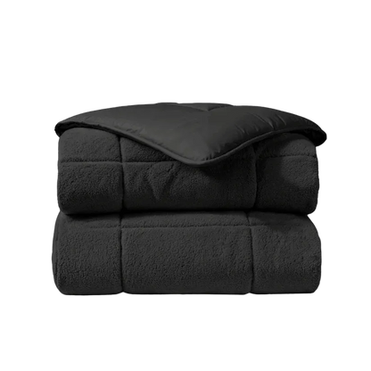 Het Zelesta Teddybed - Antraciet is een gevouwen dekbed met een gladde bovenkant en een zachte, fleece-achtige teddystof onderkant, afgebeeld tegen een witte achtergrond.