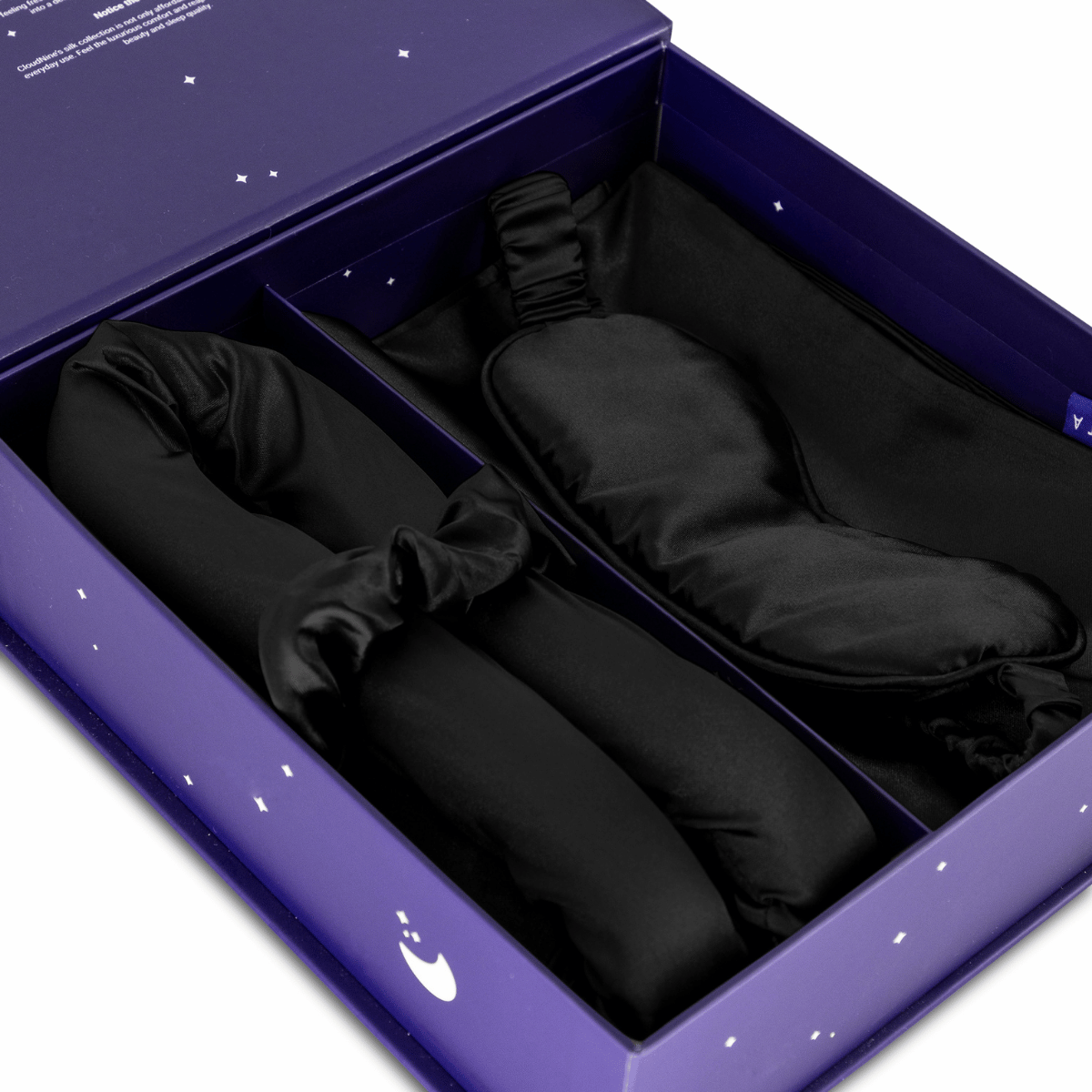 De Zelesta Sleeping Beauty Set - Universal Black heeft een paarse doos met een zwart slaapmasker en twee zwarte elastische stoffen items - perfect voor een anti-verouderingsroutine of om te combineren met een Mulberry zijden kussensloop.