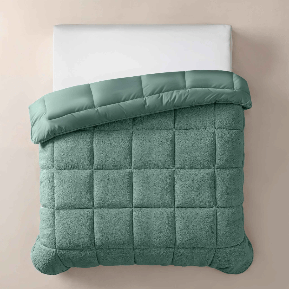 Een bovenaanzicht van het Zelesta Teddybed - Groen, netjes opgemaakt met een wit kussen en een groen pluche dekbed met structuur, tegen een beige achtergrond.