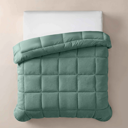 Een bovenaanzicht van het Zelesta Teddybed - Groen, netjes opgemaakt met een wit kussen en een groen pluche dekbed met structuur, tegen een beige achtergrond.