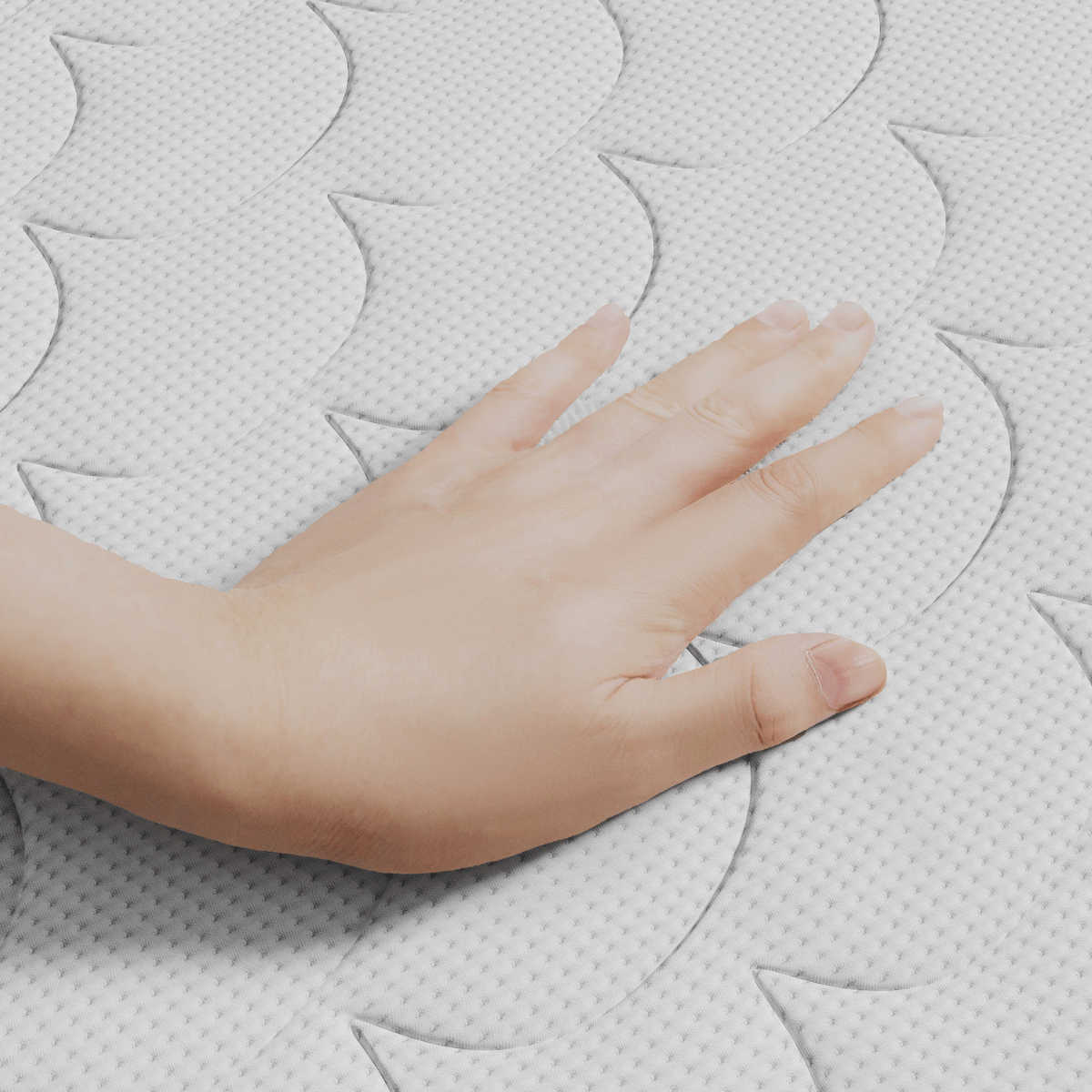 Een hand drukt op het witte, gewatteerde oppervlak van de Topdekmatras - Hybrid Koudschuim Tencel Tijk, waardoor het golfachtige patroon en het drukverlagende comfort zichtbaar worden.