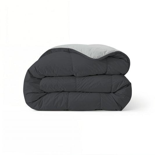 Het Zelesta Comfort Duo Dekbed heeft een netjes gevouwen ontwerp met een zachtzwarte buitenkant en zilvergrijze binnenkant, wat doet denken aan klassieke dekbedden, en wordt gepresenteerd tegen een effen witte achtergrond.