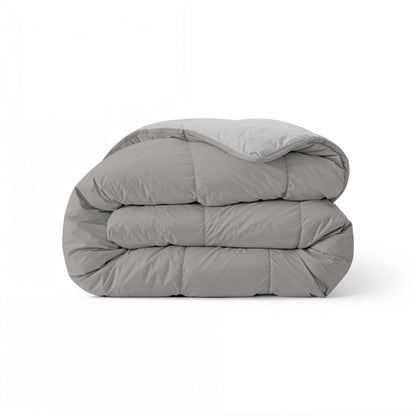 Het Zelesta Comfort Duo Dekbed in grijs & zacht grijs, netjes opgevouwen en ideaal voor alle seizoenen, wordt getoond tegen een effen witte achtergrond.