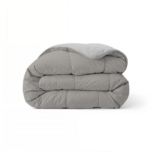 Het Zelesta Comfort Duo Dekbed in grijs & zacht grijs, netjes opgevouwen en ideaal voor alle seizoenen, wordt getoond tegen een effen witte achtergrond.