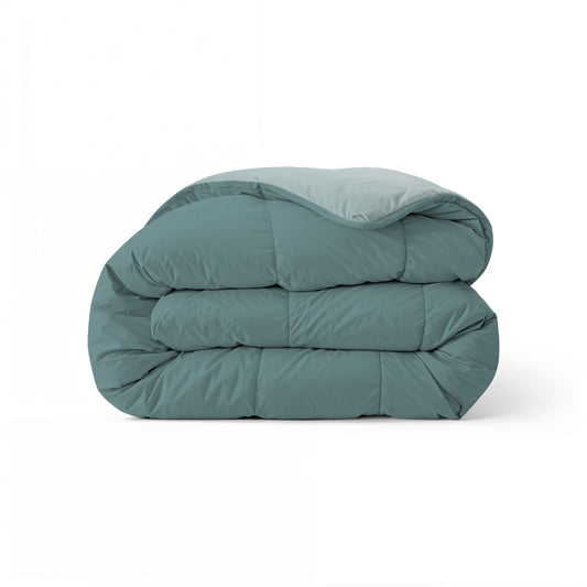 Het Zelesta Comfort Duo Dekbed in Mineraal & Licht blauw is opgevouwen te zien, met een glad gewatteerd oppervlak tegen een witte achtergrond - ideaal als dekbed voor het hele seizoen voor comfort het hele jaar door.