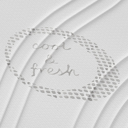 Gestructureerde witte stof met ronde stippen en "cool & fresh" handgeschreven in het midden. Subtiele plooien roepen het comfort op van een koele frisse tijk op de Topdekmatras - NASA Schuim Cool Fresh Tijk.
