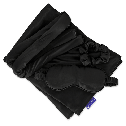 De Zelesta Sleeping Beauty Set - Universal Black, met een Mulberry zijden kussensloop, slaapmasker, scrunchie en haarbandjes, is elegant gerangschikt op een witte achtergrond - perfect voor een anti-aging slaaproutine.