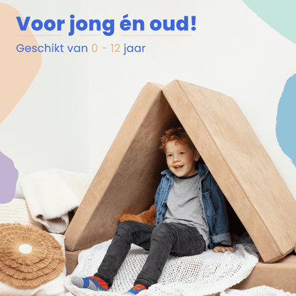 Een jongetje lacht in een driehoekige tent gemaakt van kussens en de BAAAP - De geliefde speelbank - Moon Creme, omringd door dekens en kussens. De Nederlandse tekst erboven nodigt kinderen uit om te genieten van eindeloos speelplezier.