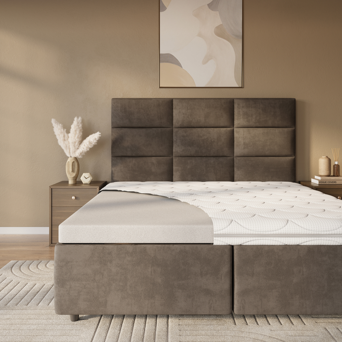 Een moderne slaapkamer met een bruin gestoffeerd bed, een Topdekmatras - NASA Schuim Tencel Tijk voor comfort, de matrastopper gedeeltelijk teruggetrokken, een houten nachtkastje, decoratieve vazen en abstracte muurkunst.