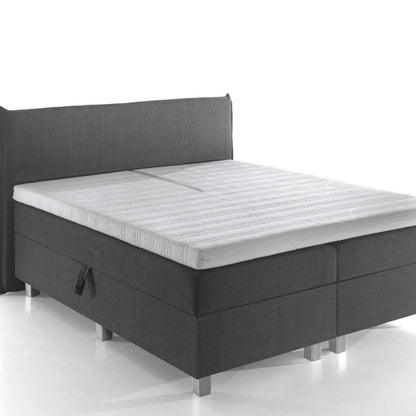 De Silver Line Split Topper - NASA Traagschuim biedt drukverlagende ondersteuning op een modern bed met donkergrijze bekleding, hoofdbord en matras tegen een witte achtergrond voor optimaal comfortabel slapen.