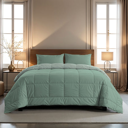 Een netjes opgemaakt bed met het Zelesta Comfort Duo Dekbed in mintgroen en lichtgroen, gecombineerd met bijpassende kussens, staat tussen twee nachtkastjes met lampen, omlijst door hoge ramen met transparante en beige gordijnen.