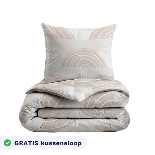 De Zelesta Kiddybed Katoen - Dune Dreams set bestaat uit een gevouwen beige en wit anti-allergie dekbed en bijpassend kussen met abstract patroon, plus een label waarop staat dat er een gratis kussensloop wordt meegeleverd.