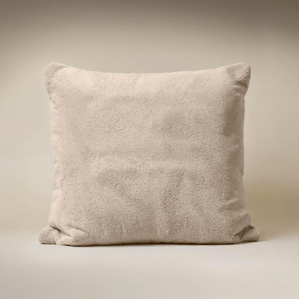 Het Zelesta Teddybed - Taupe, een vierkant kussen met zachte teddystoftextuur, is geplaatst tegen een neutrale achtergrond.
