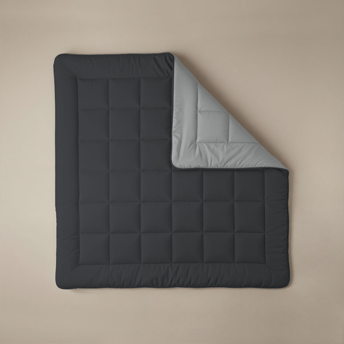 Het Zelesta Comfort Duo Dekbed heeft een zacht zwart gewatteerde bovenkant en zilvergrijze onderkant, weergegeven op een neutrale achtergrond met een omgeslagen hoek - een all-season essential geïnspireerd op klassieke dekbedden.