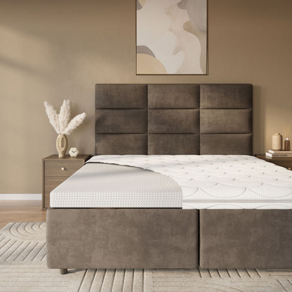 Een moderne slaapkamer met een bruin gestoffeerd bed, een Topdekmatras - Latex Schuim Tencel Tijk met een hoekuitsparing, een nachtkastje met pampagras in een vaas en abstracte muurkunst.
