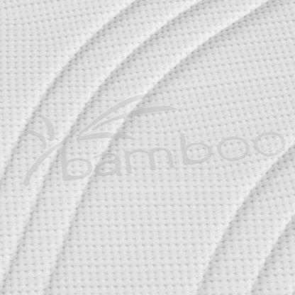 Close-up van de witte structuurstof van Topdekmatras - Comfortschuim Bamboe Tijk, met een bamboe label in reliëf, bladmotief, gebogen lijnen en stippenpatroon. Het huisstofmijtwerende materiaal biedt extra comfort en hygiëne.