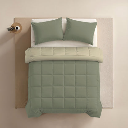 Een netjes opgemaakt bed met olijfgroen kussens en dekbed, crème lakens en een rond nachtkastje met een plant - perfect om het Zelesta Comfort Duo Dekbed - Olijfgroen & Crème te accentueren.