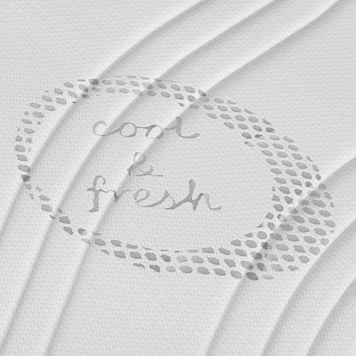 Gestructureerde witte stof met "cool & fresh" in cursief en een gestippeld ovaal patroon - ideaal voor de Topdekmatras - Comfortschuim Cool Fresh Tijk, ontworpen om huisstofmijtwerend te zijn.