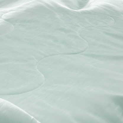 Close-up van de Zelesta Cooling Blanket in mintgroen, met een doorgestikt ontwerp met golvende stiksels die de koele textuur en subtiele schaduwen benadrukken.