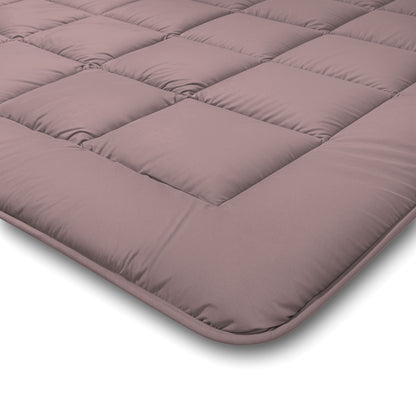 Een close-up van het Zelesta Comfort Duo Dekbed in oudroze & lichtroze, met een gewatteerd, gewatteerd oppervlak met vierkante stiksels - ideaal voor gebruik als laag voor alle seizoenen of voor extra comfort onder klassieke dekbedden.