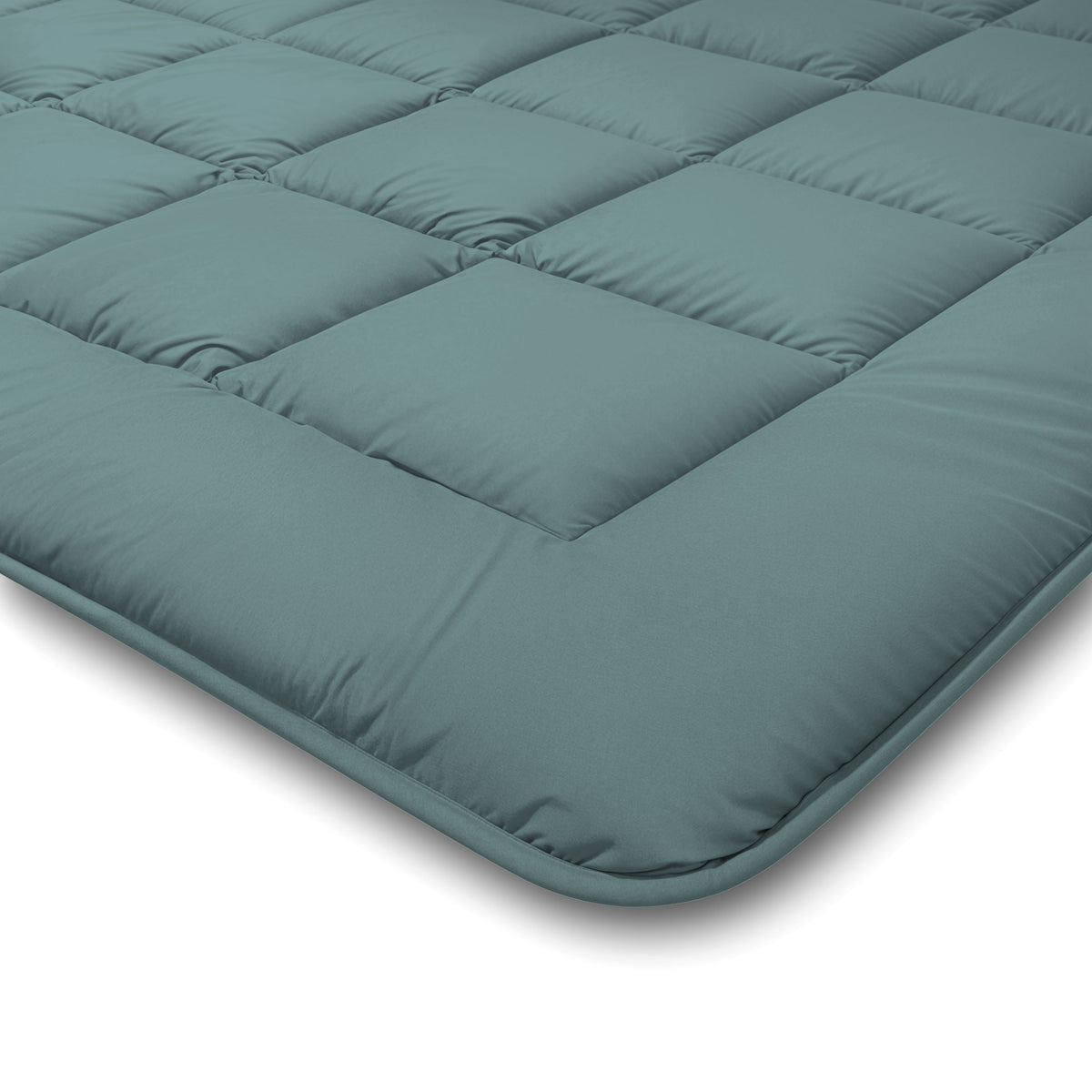 Close-up van het Zelesta Comfort Duo Dekbed in mineraal en lichtblauw, met een groenblauw doorgestikt dessin met vierkante stiksels en een zacht, gedempt oppervlak op een witte ondergrond.