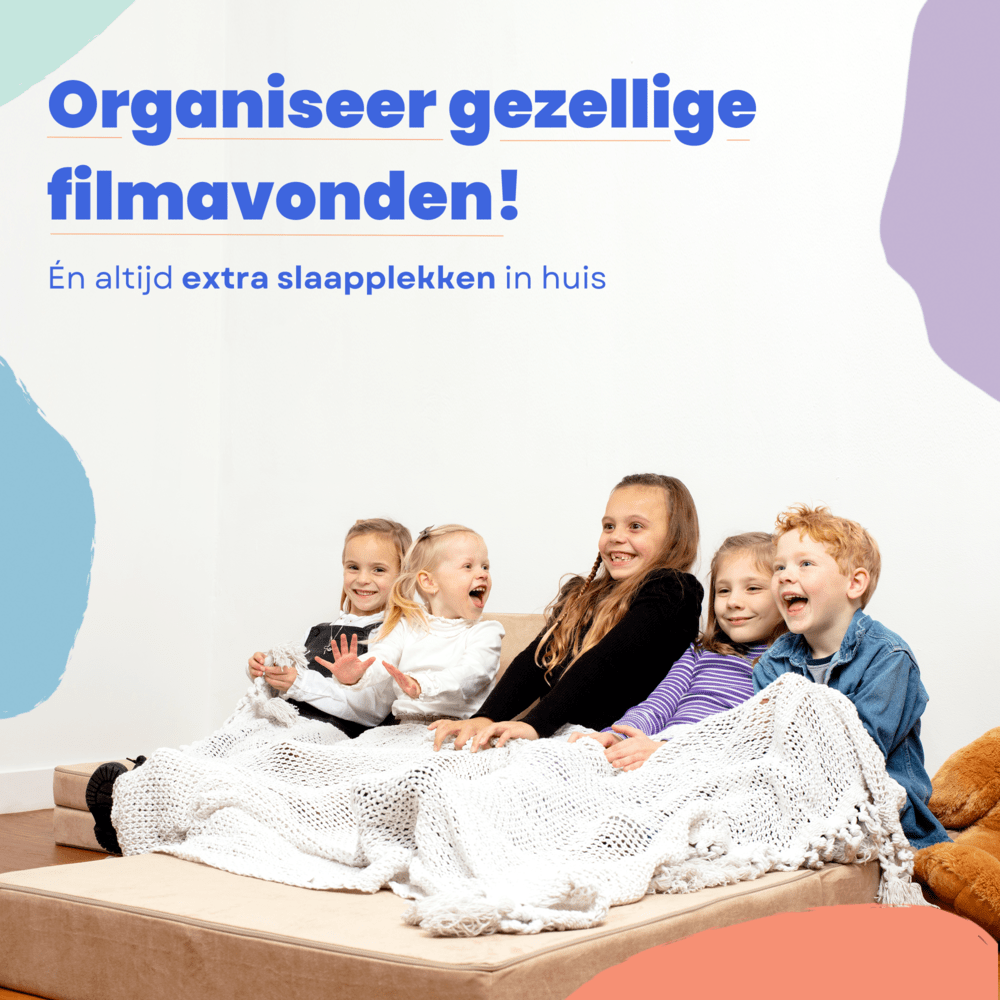Vier kinderen zitten en liggen op de BAAAP speelbank in Emerald Green, onder een deken, lachend en blij. Ontdek urenlang speelplezier én gezellige filmavonden thuis met deze geliefde Nederlandse speelbank!.