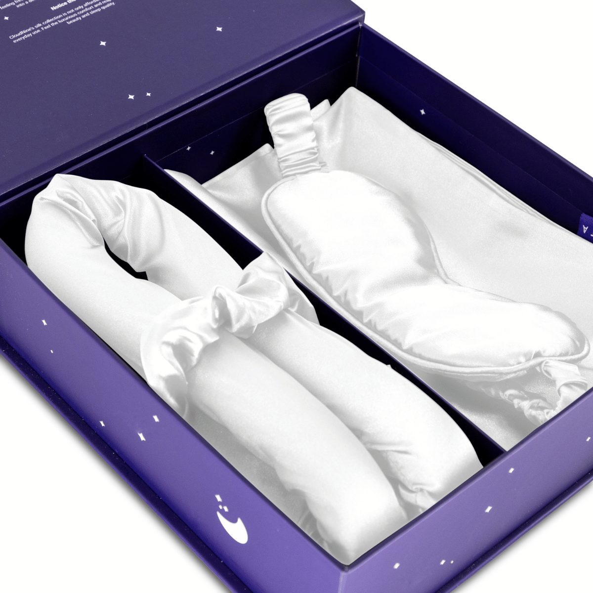 De Zelesta Sleeping Beauty Set - Wonderful White heeft een wit Mulberry zijden slaapmasker voor anti-veroudering en een bijpassende gewatteerde hoofdband, allemaal in een paarse doos met witte ster- en maanontwerpen.