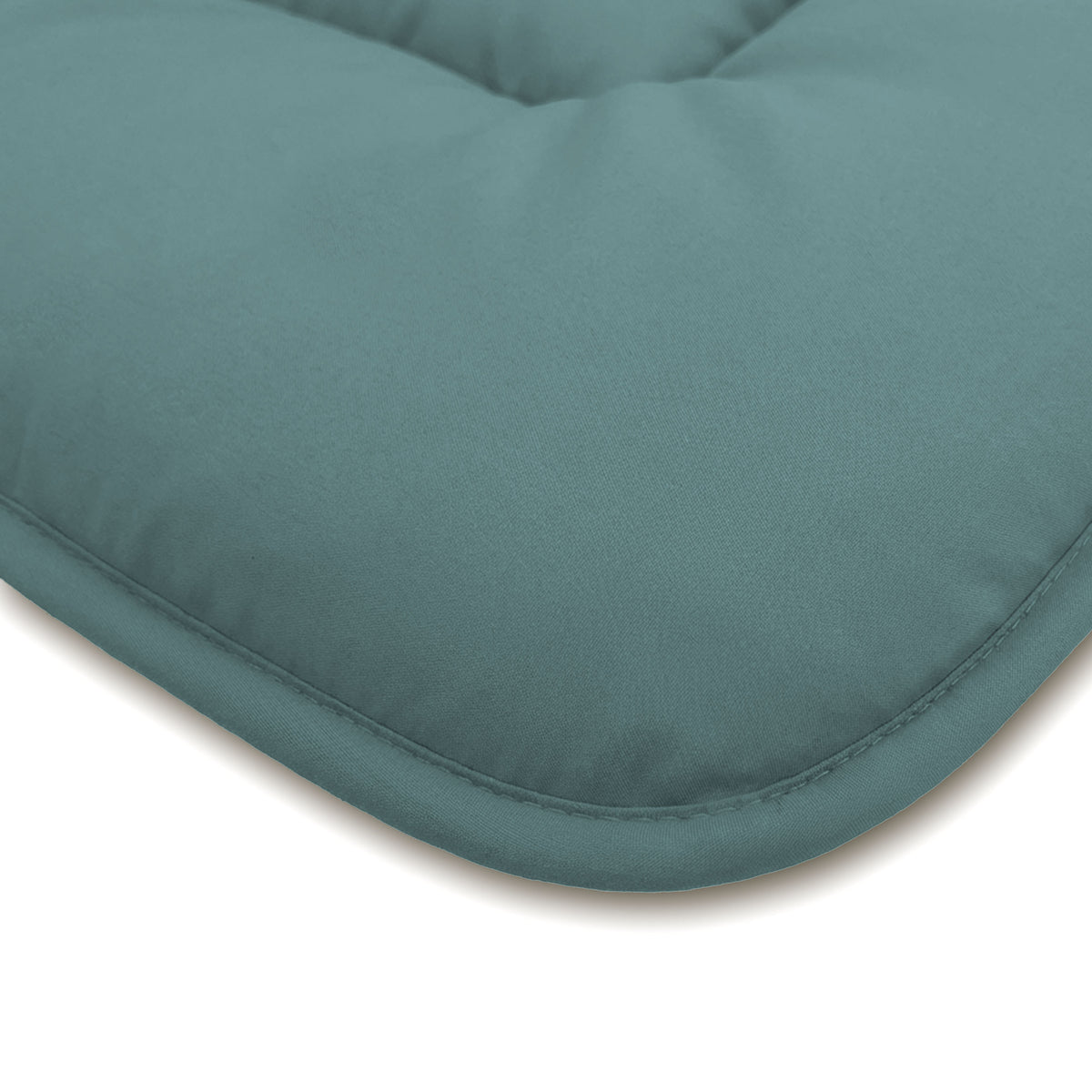 Close-up van een groenblauw, gewatteerd kussen met zichtbare stiksels en een glad oppervlak, dat doet denken aan de zachtheid van het Zelesta Comfort Duo Dekbed - Mineraal & Licht blauw.