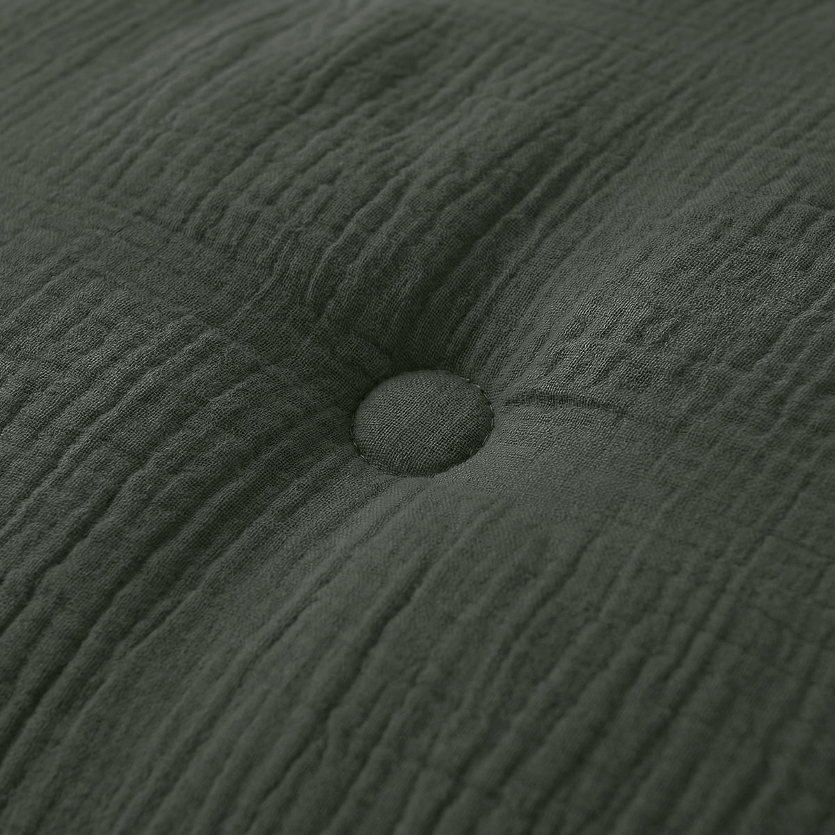 Close-up van het Zelesta Japandibed Katoen Mousseline kussen in donkergroen, met dubbelgeweven katoen en een centrale knoop voor een luxe, getextureerde afwerking.