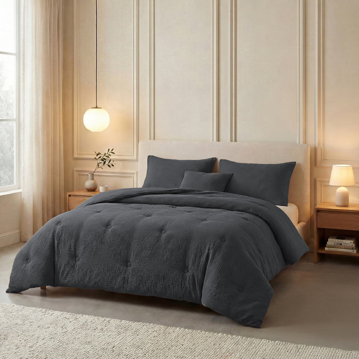 Een bed in het Zelesta Japandibed Katoen Mousseline - Antraciet beddengoed, met twee kussens en een klein kussen, staat tussen houten nachtkastjes met lampen in een zacht verlichte slaapkamer.