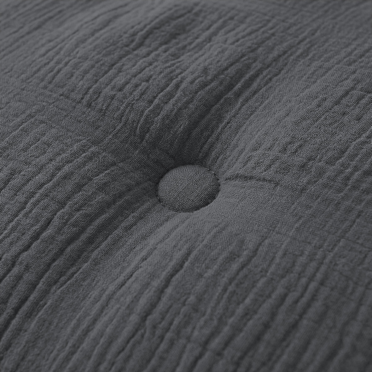 Close-up van een antraciet kussen met een enkele knoop, perfect passend bij het Zelesta Japandibed Katoen Mousseline beddengoed.
