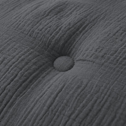 Close-up van een antraciet kussen met een enkele knoop, perfect passend bij het Zelesta Japandibed Katoen Mousseline beddengoed.