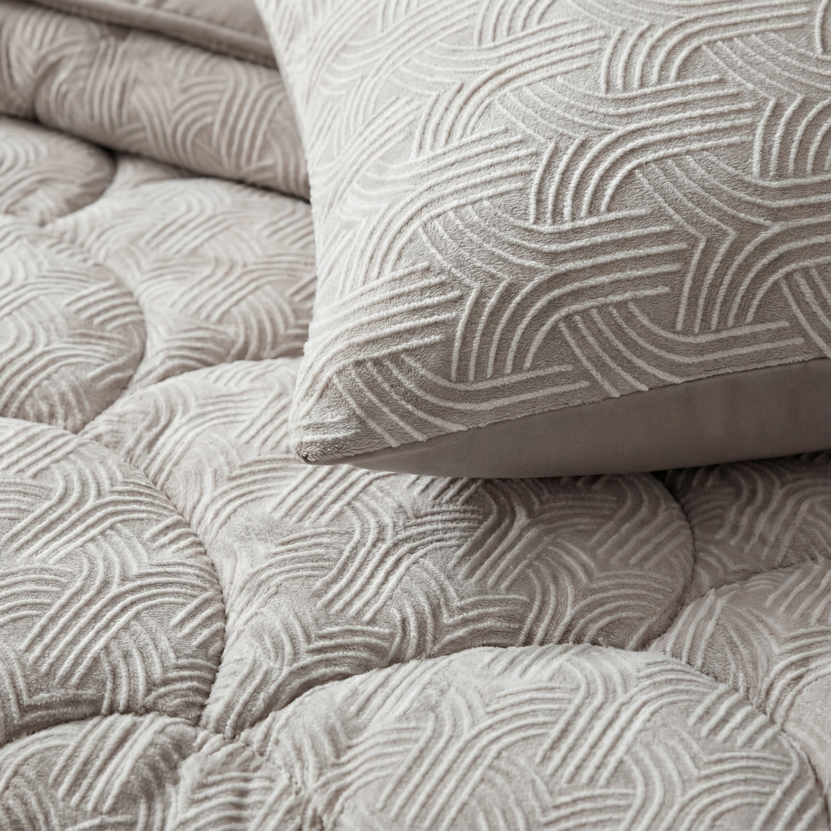 Close-up van het Zelesta Flanel Luxe - Taupe & Grijs kussen en sprei in lichtgrijs met een verhoogd geometrisch patroon, ideaal om te combineren met een temperatuurregulerend dekbed voor maximaal comfort.