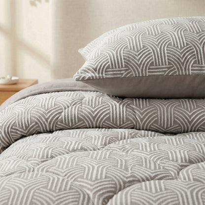 Close-up van een netjes opgemaakt bed met het Zelesta Flanel Luxe dekbed in taupe & grijs en bijpassend kussen, naast een houten nachtkastje.
