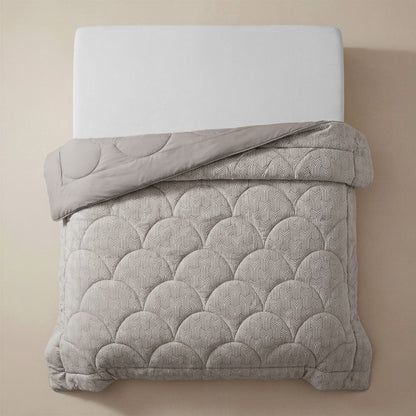 Een netjes opgemaakt bed met een wit matras en het Zelesta Flanel Luxe - Taupe & Grijs gewatteerde microvezel dekbed in lichtgrijs, met een geschulpt patroon, van boven getoond tegen een beige achtergrond.