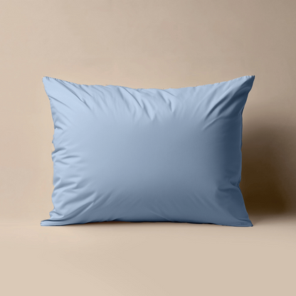 De Zelesta Premiumbed Kussensloop Set van 2 in Dream Blue, met een gladde perkal katoenen afwerking, staat rechtop tegen een beige achtergrond en brengt een vleugje premiumbed stijl in je ruimte.