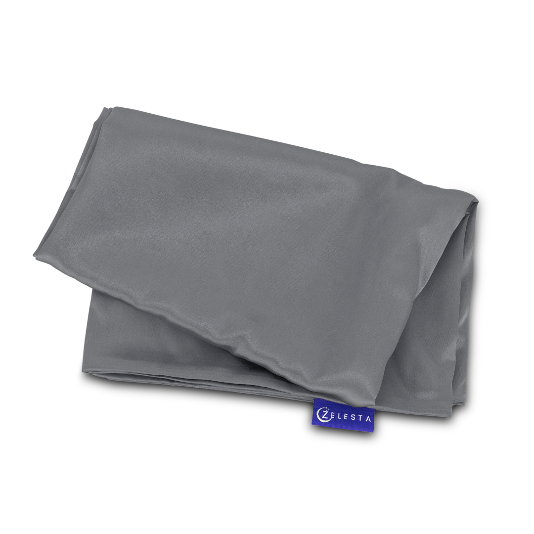 Een netjes gevouwen grijs doekje met een klein blauw ZLESTA label, uit de Zelesta Sleeping Beauty Set - Amazing Anthracite, biedt Mulberry zijde-achtige zachtheid en kwaliteit - perfect voor een anti-aging slaaproutine.