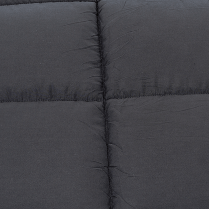 Close-up van donkergrijze gewatteerde stof met zichtbare vierkante stiksels, ideaal voor een knus dekbed zoals het Zelesta Teddybed - Antraciet.