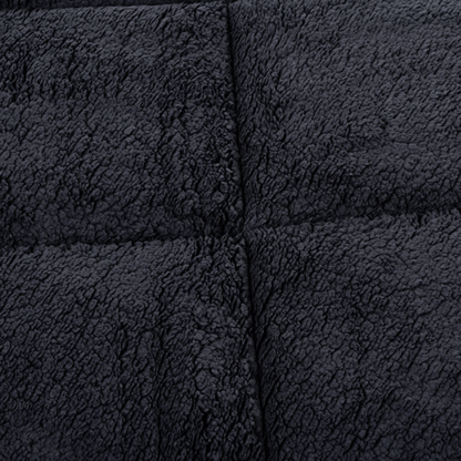Close-up van het Zelesta Teddybed - Antraciet, met donkergrijze teddystof met structuur en gestikte kruisnaden, ideaal voor knus comfort.
