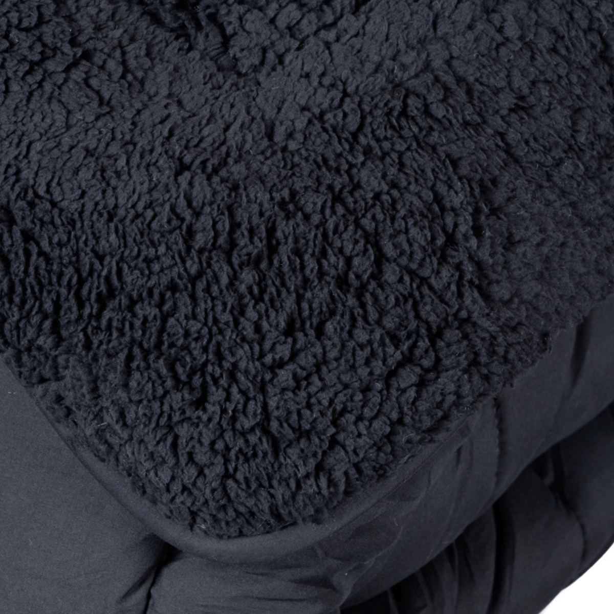 Close-up van het Zelesta Teddybed - Antraciet, met zwart structuurfleece materiaal dat lijkt op teddystof dekbedstof.