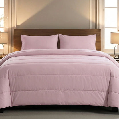 Een netjes opgemaakt bed met het Zelesta Comfort Uni Dekbed in Oud Roze en twee bijpassende kussens, tegen een houten hoofdeinde, biedt het hele jaar door comfort, met lampen op nachtkastjes aan weerszijden.