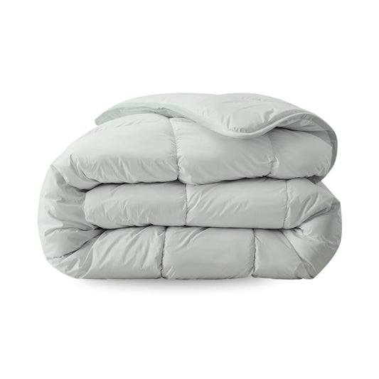 Een gevouwen, mistgroen Zelesta Everyday Uni Dekbed met een doorgestikt dessin wordt getoond op een witte achtergrond - een all season dekbed en overtrek in één voor ultiem gemak en comfort.