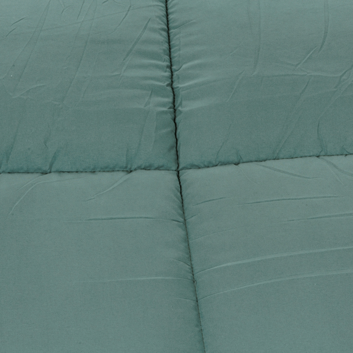 Een close-up van het Zelesta Teddybed - Groen laat de groenblauwe gewatteerde teddystof stof zien, compleet met zichtbare stiksels en gezellige pluche dekbed-achtige rimpels.