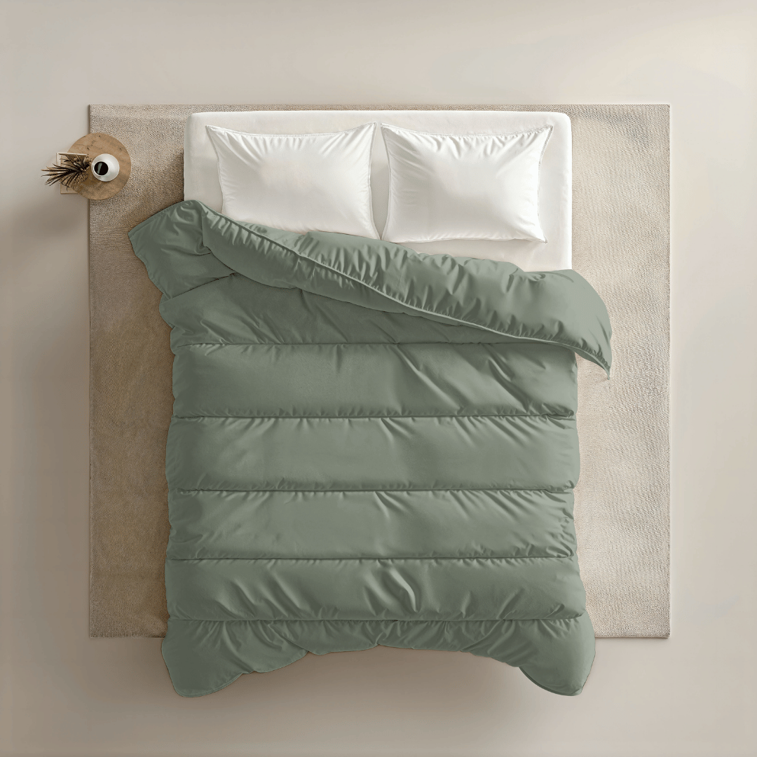 Een keurig opgemaakt bed met twee witte kussens en een Zelesta Royalbed - Pastel Green dekbed ligt op een crèmekleurig vloerkleed, naast een nachtkastje met een vaas, alles van bovenaf gezien.