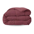 De Zelesta Pure Uni Dekbed Katoen in bordeaux rood, met een doorgestikt dessin, wordt getoond opgevouwen tegen een witte achtergrond - perfect voor optimaal slaapcomfort.